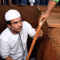 Sebagai bentuk penghormatan terakhir, sang menantu, Teddy Syach langsung turun ke liang lahat untuk membantu menurunkan jenazah. Teddy pula yang mengadzankan jenazah sebelum ditutup dengan tanah.  (Adrian Putra/Bintang.com)