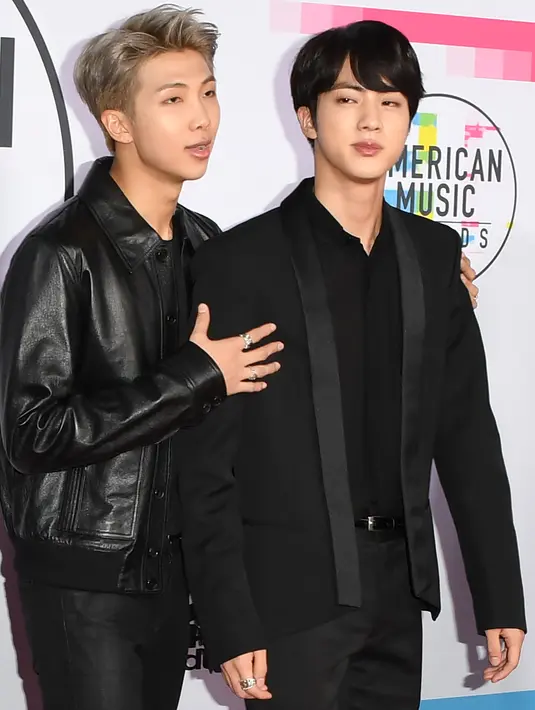 Dua personel boyband Korsel, Bangtan Boys alias BTS berpose di karpet merah ajang American Music Awards 2017 di Los Angeles, Minggu (19/11). Grup vokal dengan gaya dance keren itu merupakan grup K-pop pertama yang tampil di ajang AMA. (Mark Ralston/AFP)