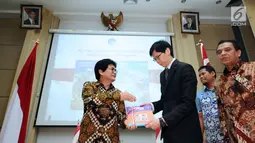 Dirjen Penyelenggaraan Pos dan Informatika, M Ramli (kiri) menyerahkan cenderamata kepada Director of Mission Singapore, Jonathan Han usai penandatanganan dan peluncuran perangko bersama di Jakarta, Kamis (7/9). (Liputan6.com/Helmi Fithriansyah)