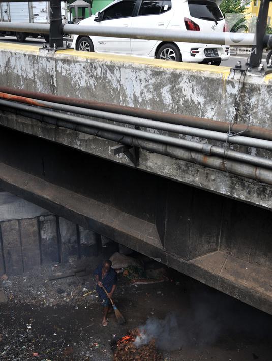Warga membuat arang di kolong jembatan, Jakarta, Kamis (14/2). Kolong jembatan yang berada di kawasan Jakarta Timur tersebut digunakan oleh warga setempat untuk menernak hewan dan membuat arang akibat kurangnya lahan. (Merdeka.com/Iqbal S. Nugroho)