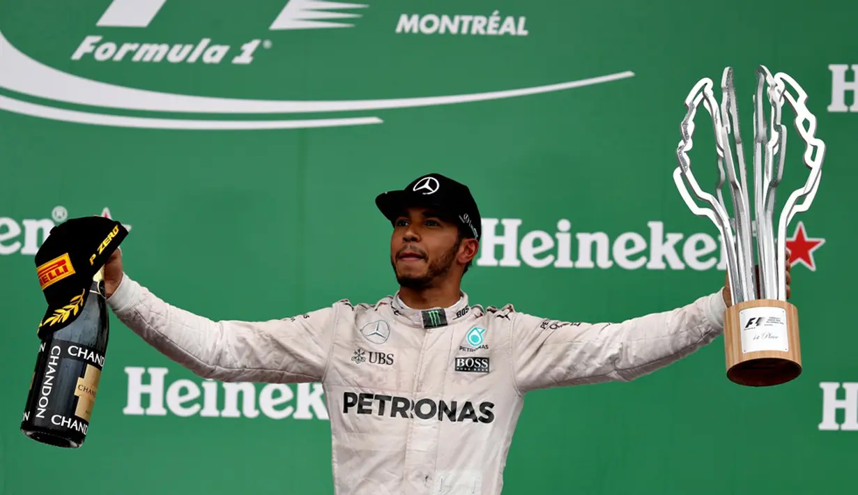 Lewis Hamilton dengan trofi juara F1 GP Kanada di Sirkuit Gilles Villeneuve, Kanada, Senin (13/6/2016) dini hari WIB. (AFP/Getty Images/Mark Thompson)