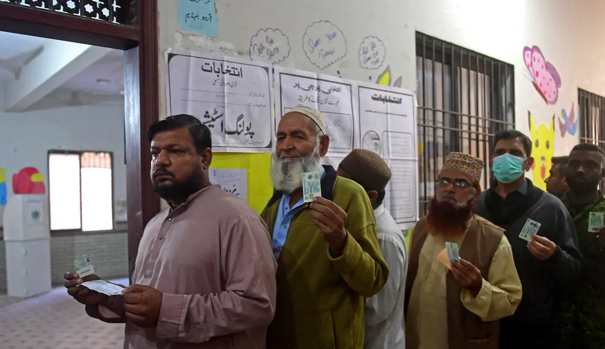 Para pemilih berdiri dalam antrian menunjukkan kartu identitas pemilih mereka di Karachi pada tanggal 8 Februari 2024. (Asif HASSAN/AFP)