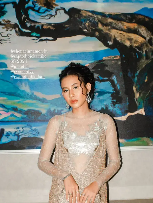 Shenina Cinnamon tampil elegan dengan dress semi transparan dari Sapto Djojokartiko. Dress ini memadukan inner silver transparan dengan dress sequin v-neck rendah [@snap.nuel]
