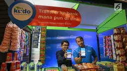 CEO & Co-Founder Kudo, Agung Nugroho (kiri) dan Agen Kudo, Dahlan (kanan) menunjukkan aplikasi digital Kudo di warung digital Jakarta, Kamis (27/6/2019). Sekitar 2 juta agen Kudo, memberikan akses yang terjangkau jutaan produk dan layanan online kepada jutaan pelanggan. (Liputan6.com/Fery Pradolo)