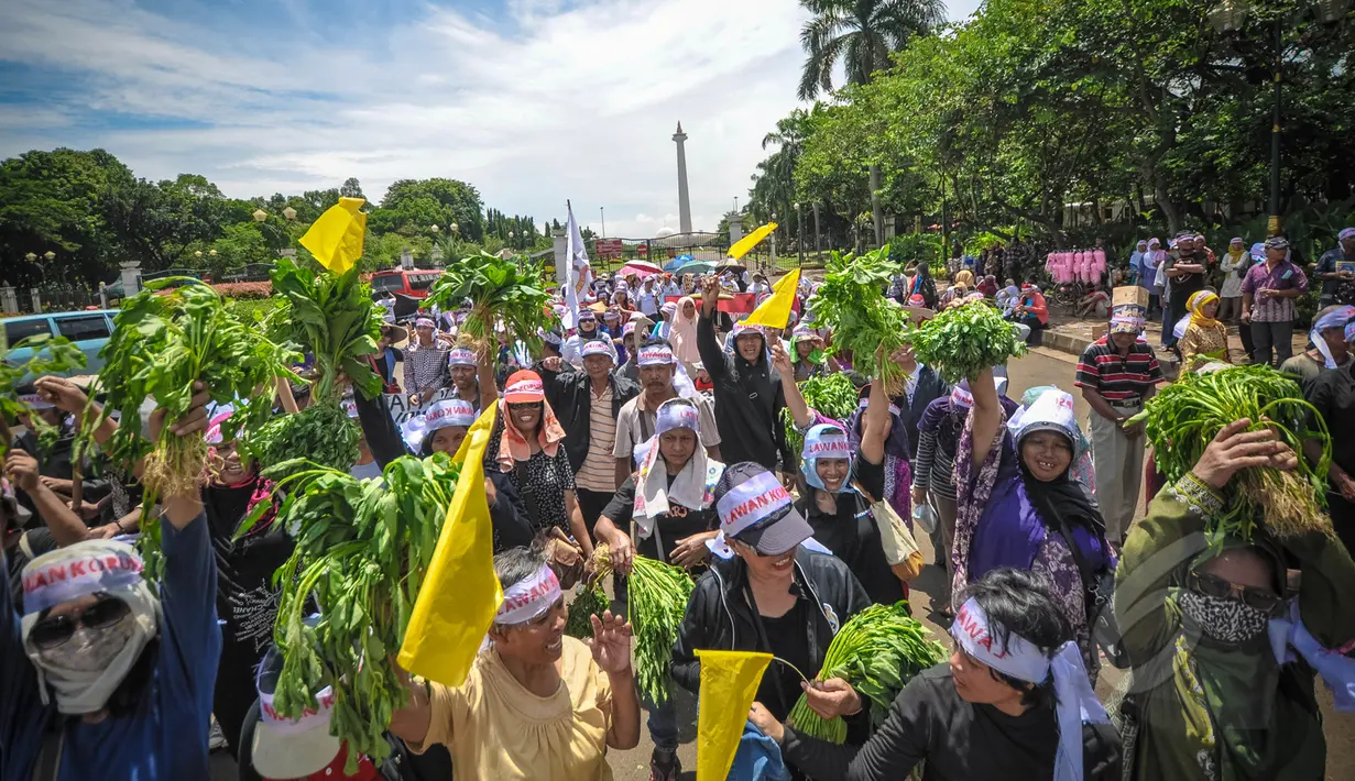 Massa membawa hasil perkebunan saat aksi Karnaval Rakyat Lawan Korupsi dari patung kuda menuju Istana Negara, Jakarta, Rabu (8/4/2015). Aksi tersebut menuntut untuk menghentikan kriminalisasi terhadap KPK. (Liputan6.com/Faizal Fanani)