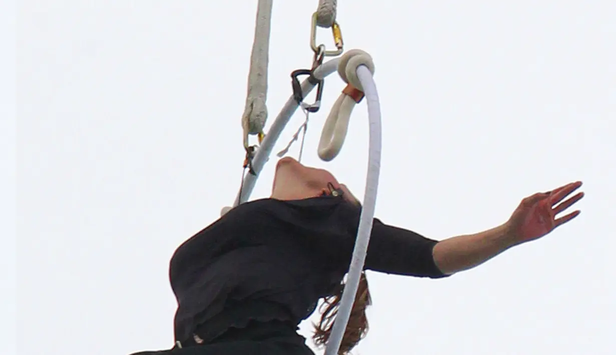 Seorang akrobatis udara asal Amerika, Erendira Wallenda bergelantungan pada sebuah helikopter menggunakan giginya, Kamis (15/7). Aksi bergelantungan di atas air terjun Niagara dengan giginya itu berhasil memecahkan rekor dunia. (AP Photo/Bill Wippert)