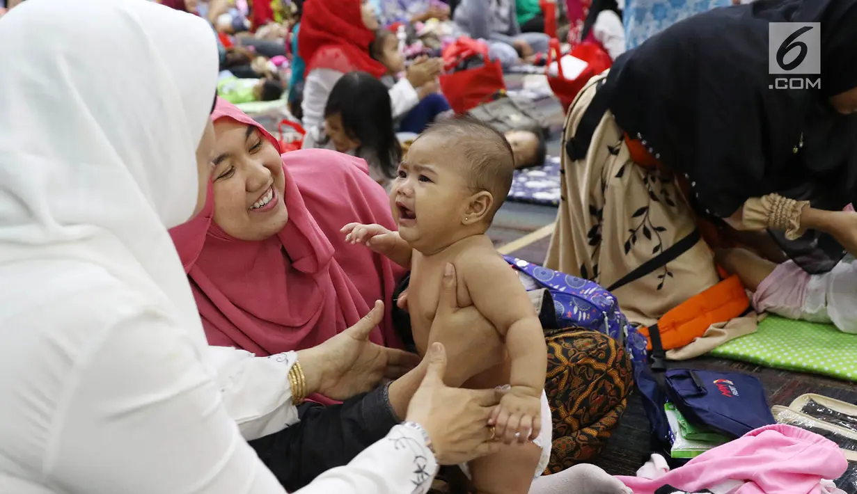Seorang bayi menangis ketika akan dipijat dalam acara pijat massal bayi di Gedung Kementerian Kesehatan, Jakarta, Selasa (7/11). Acara ini diikuti 300 bayi dan anak bawah dua tahun. (Liputan6.com/Immanuel Antonius)