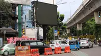 Kendaraan melintas di depan sebuah videotron di simpang Jalan Iskandarsyah, Jakarta Selatan, Minggu (2/10). Garis polisi terpasang terkait insiden videotron itu yang sempat memutar tayangan porno pada Jumat, 30 September 2016. (Liputan6.com/Helmi Afandi)