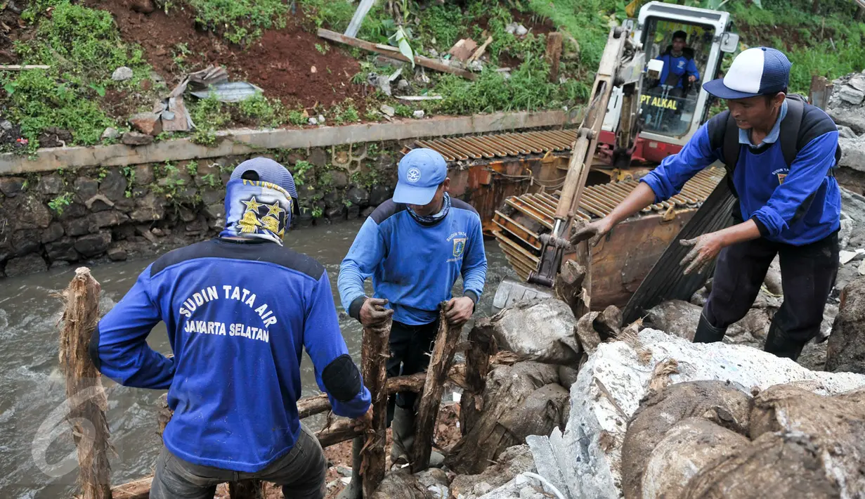 Petugas Tata Air atau pasukan biru membuat pagar untuk penahan saat menambal turap yang longsor di Kalibaru, Desa Putra, Jakarta Selatan, Rabu (22/3). (Liputan6.com/Yoppy Renato)