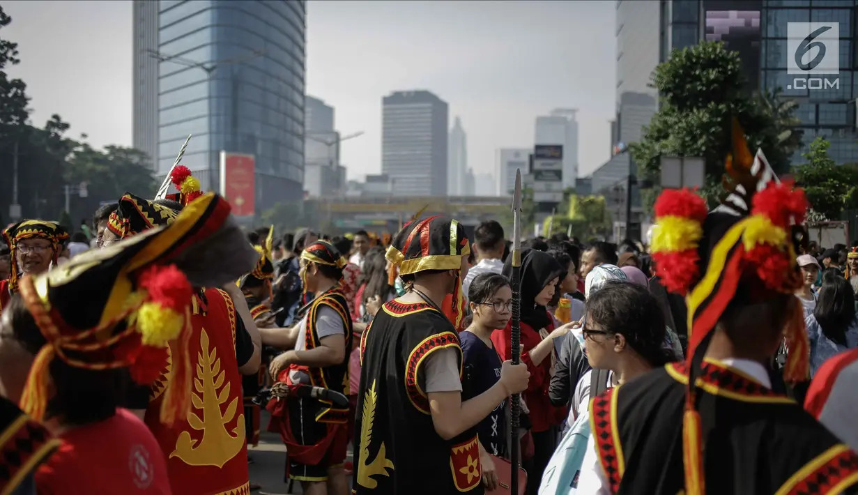 Warga mengenakan atribut budaya Kepulauan Nias saat Car Free Day di Kawasan Jalan Sudirman, Jakarta, Minggu (4/3). Pagelaran ini untuk memperkenalkan kebudayaan Kepulauan Nias oleh para pemuda asal Nias se-Jabodetabek. (Liputan6.com/Faizal Fanani)