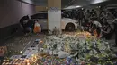Para pengunjuk rasa menyalakan lilin di dekat bunga-bunga di lokasi tempat mahasiswa Alex Chow Tsz-lok jatuh di Hong Kong (8/11/2019). Chow ditemukan terbaring dengan genangan darah di sebuah tempat parkir mobil, yang menjadi sasaran penembakan gas air mata oleh polisi. (AP Photo/Kin Cheung)