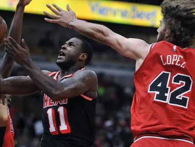 Pemain Miami Heat, Dion Waiters (tengah) melakukan tembakan saat diadang pemain Chicago Bulls, Robin Lopez (42) dan Justin Holiday (7) pada laga NBA basketball game di United Center, Chicago, (26/11/2017). Miami Heat menang 100-93.  (AP/Paul Beaty)