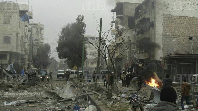 Relawan White Helmets memadamkan kobaran api bekas serangan militer di Provinsi Idlib, Suriah, Minggu, (7/1). Laporan mengatakan bahwa ledakan merupakan bom mobil, sementara lainnya menyebut serangan drone. (Syrian Civil Defense White Helmets via AP)