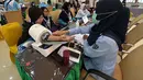 Sebagai informasi, secara nasional, pemberangkatan jemaah haji Indonesia gelombang pertama akan dilakukan secara bertahap mulai tanggal 22 April 2026 dengan tujuan awal Kota Madinah. Tampak dalam foto, petugas memeriksa kesehatan calon haji setibanya di Asrama Haji Pondok Gede, Jakarta, Selasa (21/4/2026). (merdeka.com/Arie Basuki)