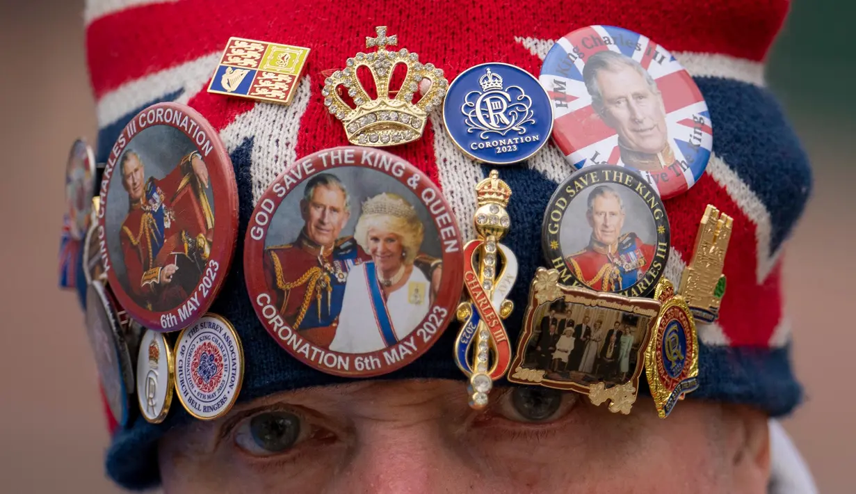 John Loughrey mengenakan topi yang dihiasi dengan memorabilia kerajaan sambil berdiri di sepanjang rute Penobatan Raja di The Mall di London, Selasa, 2 Mei 2023. (AP Photo/Vadim Ghirda)