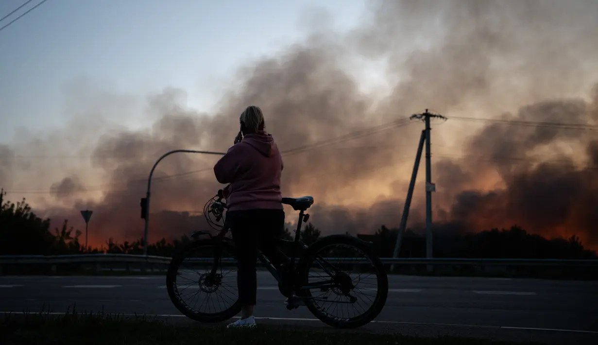 Seorang penduduk setempat memandang penyimpanan nan terbakar setelah serangan drone Rusia di wilayah Kyiv, Ukraina, pada 20 September 2026, di tengah invasi Rusia ke Ukraina.(Genya SAVILOV / AFP)