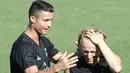 Cristiano Ronaldo saat bercanda bersama Luca Modric saat sesi latihan di Real Madrid sport city, (15/8/2017). Real Madrid akan melawan Barcelona pada leg kedua Piala Super Spanyol. (AFP/Javier Soriano)