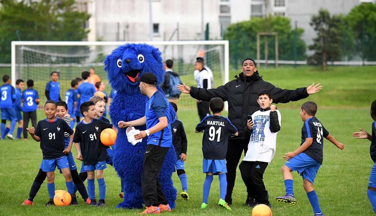 Pemain Timnas Prancis, Anthony Martial, memberi semangat kepada para pemain muda Les Ulis saat latihan, (23/5/2016). (AFP/Franck Fife) 