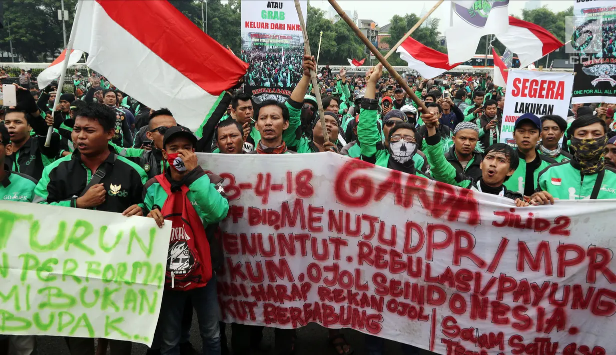 Pengemudi ojek online saat menggelar aksi unjuk rasa di depan Gedung MPR DPR, Jakarta, Senin (23/4). Unjuk rasa membuat lalu lintas di Jalan Gatot Subroto terhambat. (Liputan6.com/Johan Tallo)