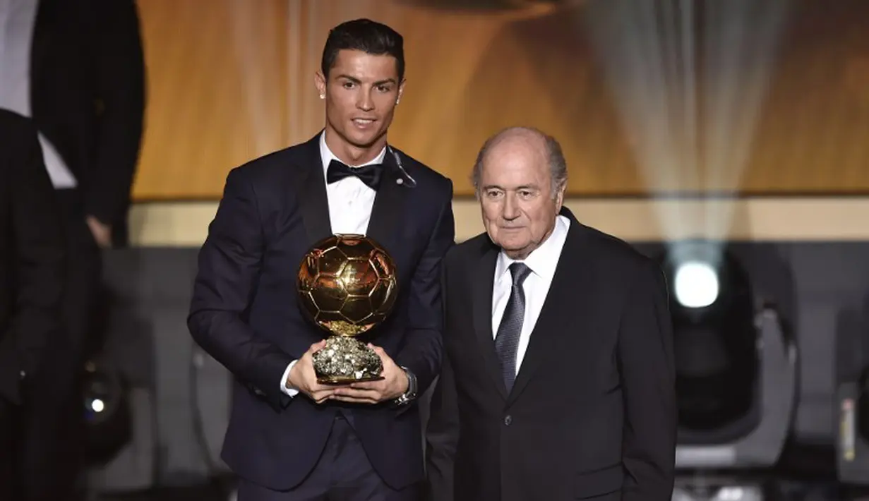 Penyerang Real Madrid Cristiano Ronaldo didampingi Presiden FIFA saat meraih penghargaan Ballon d'Or 2014 di Swiss, Senin (12/1/2015). (AFP PHOTO/Fabrice COFFRINI)