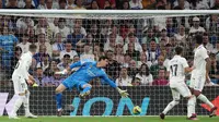 Kiper Real Madrid, Thibuat Courtois gagal menahan tembakan penyerang Villarreal, Jose Luis Morales dalam laga La Liga 2022/2023 di Stadion Santiago Bernabeu, Minggu (9/4/2023) dini hari WIB. (AFP/Pierre-Philippe Marcou)