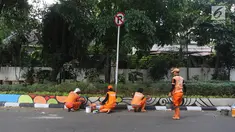 Petugas PPSU Gondangdia mengecat pembatas jalan dengan warna-warni Asian Games di kawasan Menteng, Jakarta, Kamis (12/7). Cat lukisan dinding beraneka gambar dan bentuk untuk menyambut HUT kemerdekaan RI dan Asian Games 2018. (Liputan6.com/Arya Manggala)