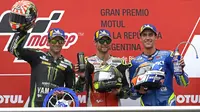 Pebalap LCR Honda, Cal Crutchlow (tengah), merayakan gelar juara pada MotoGP Argentina di Sirkuit Termas de Rio Hondo, Minggu (8/4/2018). Pebalap Inggris itu mencatatkan waktu 40 menit 36.342 detik. (AFP/Juan Mabromata)