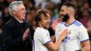 Pemain Real Madrid, Karim Benzema (kanan) merayakan kemenangan atas Manchester City bersama rekan dan pelatihnya, Luka Modric (tengah) dan Carlo Ancelotti pada laga leg kedua semifinal Liga Champions 2021/2022 di Stadion Santiago Bernabeu, Madrid, 4 Mei 2022. (AFP/Gabriel Bouys)