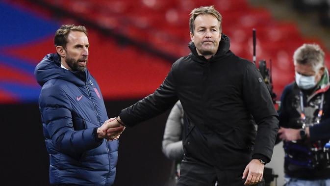 Manajer Inggris Gareth Southgate (kiri) berjabat tangan dengan Manajer Denmark Kasper Hjulmand usai pertandingan UEFA Nations League di Stadion Wembley, London, Inggris, Rabu (14/10/2020). Denmark menang 1-0. (Toby Melville/Pool via AP)