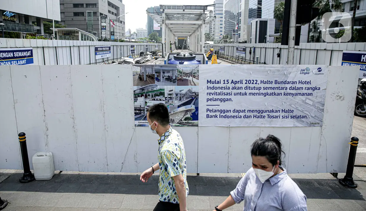 Pejalan kaki melintas di dekat Halte Bundaran HI yang sedang direvitalisasi di Jakarta, Senin (18/4/2022). PT Transjakarta menutup total 11 halte Transjakarta untuk dilakukan revitalisasi. (Liputan6.com/Faizal Fanani)
