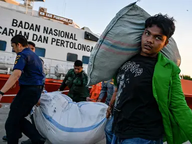 Para relawan memuat bantuan untuk korban banjir bandang di permukiman warga Provinsi Aceh, di Banda Aceh, pada 1 Desember 2025. Pemerintah melalui Badan Nasional Penanggulangan Bencana (BNPB) dan lembaga terkait lainnya, terus mempercepat distribusi bantuan logistik untuk korban bencana banjir dan tanah longsor di Aceh. (Chaideer MAHYUDDIN/AFP)