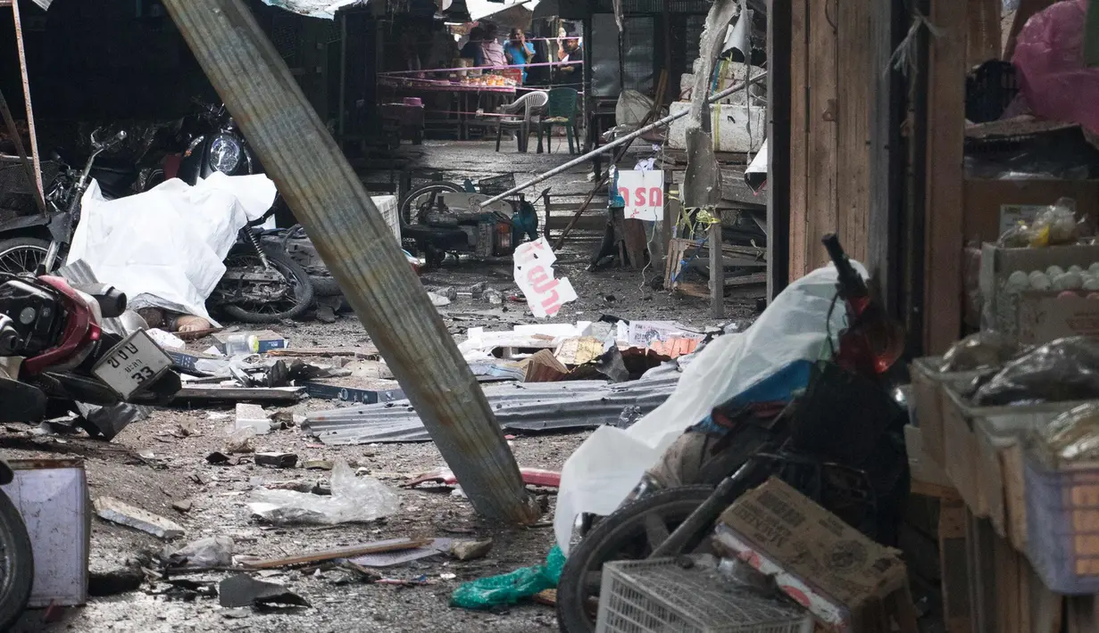 Warga melihat lokasi pengeboman di sebuah pasar di provinsi Yala, Thailand selatan (22/1). Sedikitnya tiga orang tewas dan 18 orang lainnya luka-luka akibat ledakan tesebut. (AP Photo/Somphop Suphanaranond)