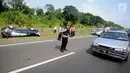 Petugas mengatur lalu lintas di lokasi terbaliknya sebuah mobil di KM 208 Tol Palikanci (Palimanan-Kanci), Jawa Barat, Rabu (21/6). Pengemudi mobil bernopol B 2247 TKL itu diduga mengantuk hingga mengakibatkan mobil terbalik. (Liputan6.com/Gempur M Surya)