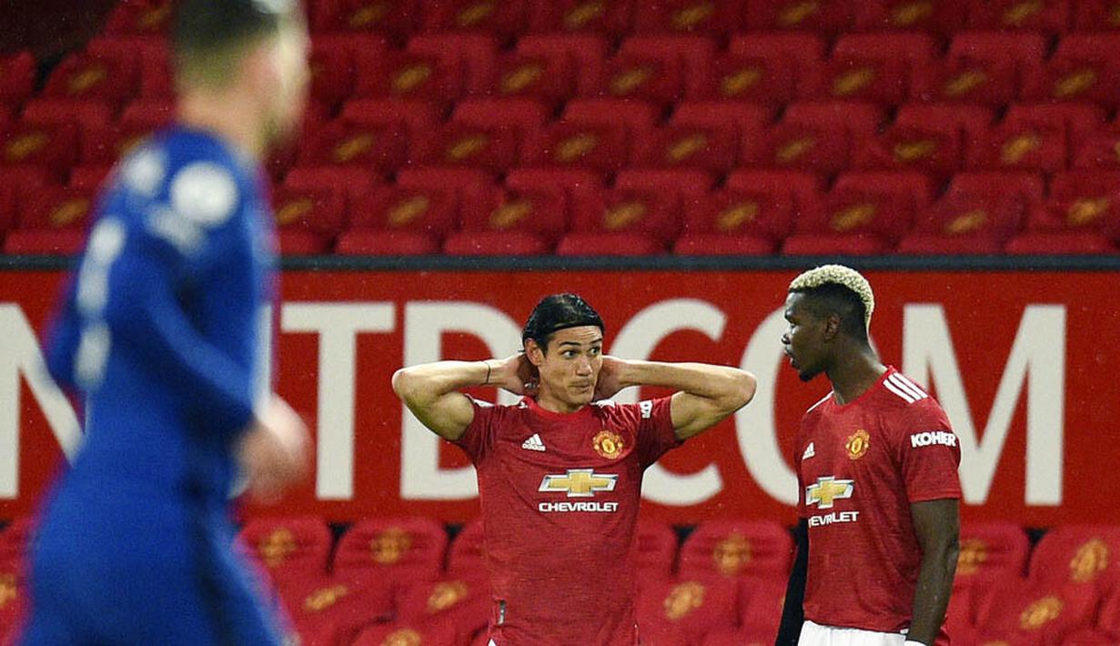 Pemain Manchester United, Edinson Cavani, berbincang dengan Paul Pogba saat pertandingan melawan Chelsea pada laga Liga Inggris di Stadion Old Trafford, Minggu (25/10/2020). Kedua tim bermain imbang 0-0. (Oli Scarff/Pool via AP)