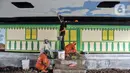 Petugas Penanganan Prasarana dan Sarana Umum (PPSU) Kelurahan Bali Mester menyelesaikan pembuatan mural di kolong Flyover Kampung Melayu, Jakarta, Selasa (7/3/2023). Pembangunan taman bermain tersebut bertujuan mengubah kolong flyover yang sebelumnya terkesan seram menjadi tempat interaksi warga sekitar sekaligus penataan kawasan. (merdeka.com/Iqbal S. Nugroho)