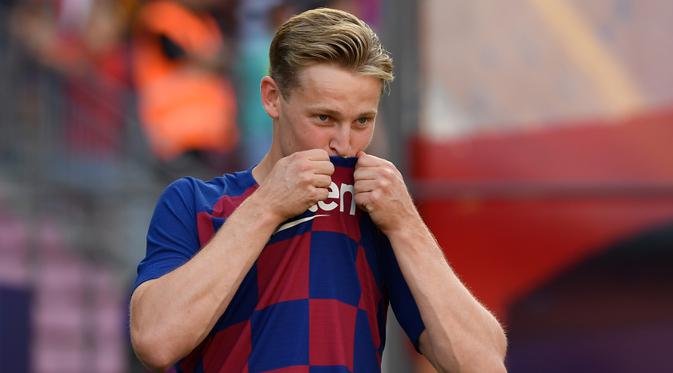 Gelandang asal Belanda Frenkie de Jong mencium logo klub barunya saat pengenalan dirinya sebagai pemain Barcelona di stadion Camp Nou, Spanyol (5/7/2019). Frenkie de Jong sangat antusias bisa bermain dengan sang superstar, Lionel Messi. (AFP Photo/Lluis Gene)