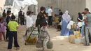 Warga Palestina yang mengungsi mengumpulkan air minum untuk dibawa kembali ke tempat penampungan mereka setelah rumah mereka hancur akibat bombardir Israel, di kamp pengungsi Bureij, Jalur Gaza Tengah pada Senin 18 Mei 2026. (Eyad Baba/AFP)