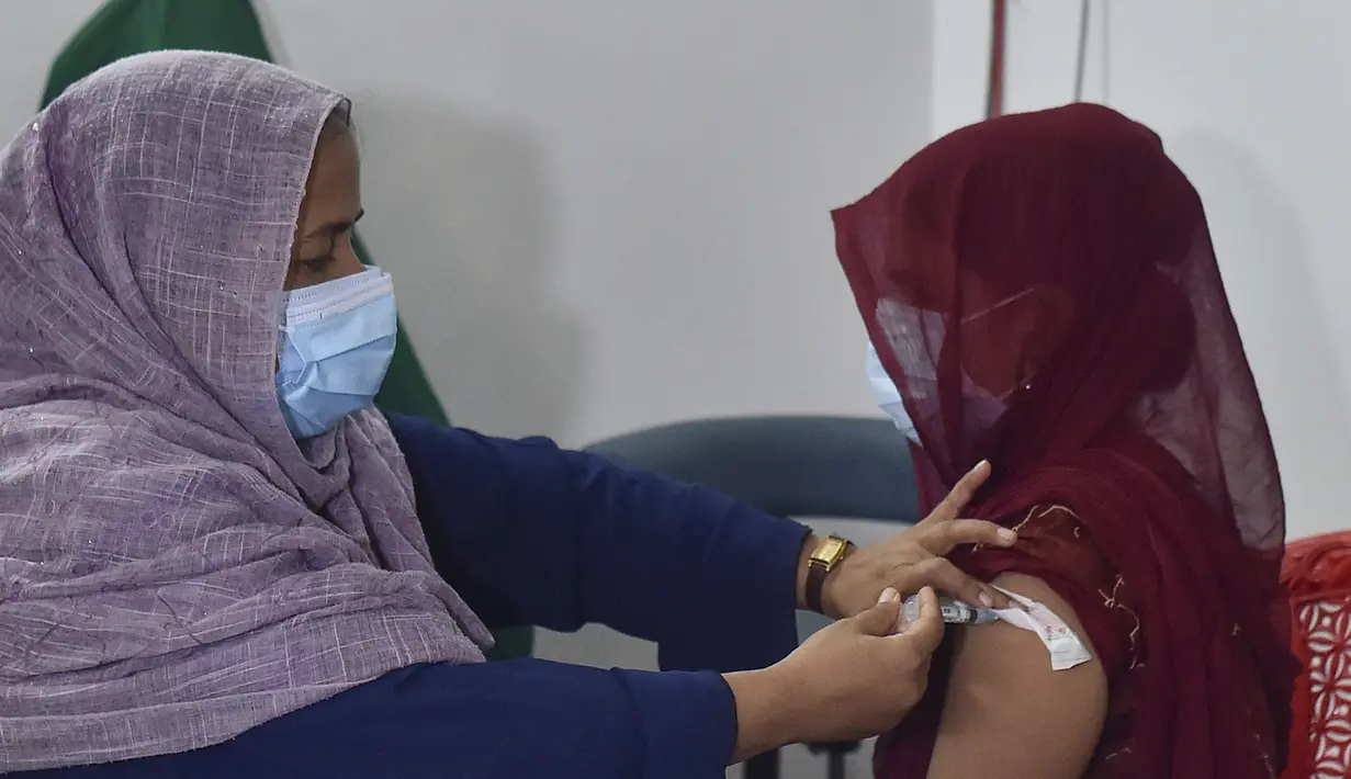 Petugas kesehatan menyuntikkan vaksin COVID-19 kepada seorang pekerja seks komersial (PSK) di Daulatdia, Bangladesh, 18 Agustus 2021. Bangladesh terus menggencarkan vaksinasi COVID-19, kegiatan ini turut menyasar para PSK di pusat prostitusi. (Munir Uz zaman/AFP)
