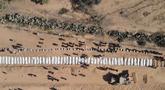 Foto udara menunjukkan warga Palestina memakamkan 54 jenazah yang tidak teridentifikasi di sebuah pemakaman di Deir al-Balah, di bagian tengah Jalur Gaza, pada 22 Oktober 2025. (Foto oleh AFP)