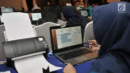 Operator memindai form C1 saat mengentri data hitung cepat berbasis aplikasi Situng Pemilu 2019 se-Provinsi DKI Jakarta di Hotel Merlyn, Minggu (21/4). Entri data dan pindai form C1 Situng Pemilu 2019 wilayah Provinsi DKI Jakarta rata-rata telah mencapai 50 persen. (merdeka.com/Iqbal Nugroho)