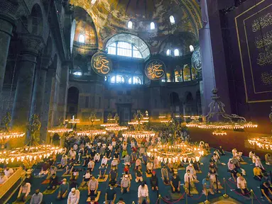 Jemaah mengenakan masker dan menerapkan jaga jarak untuk menghindari penularan COVID-19 saat melaksanakan salat Idul Adha di Hagia Sophia, Istanbul, Turki, Jumat (31/7/2020). Ini merupakan salat Idul Adha pertama di Hagia Sophia setelah dialihfungsikan dari museum menjadi masjid. (Pool via AP)