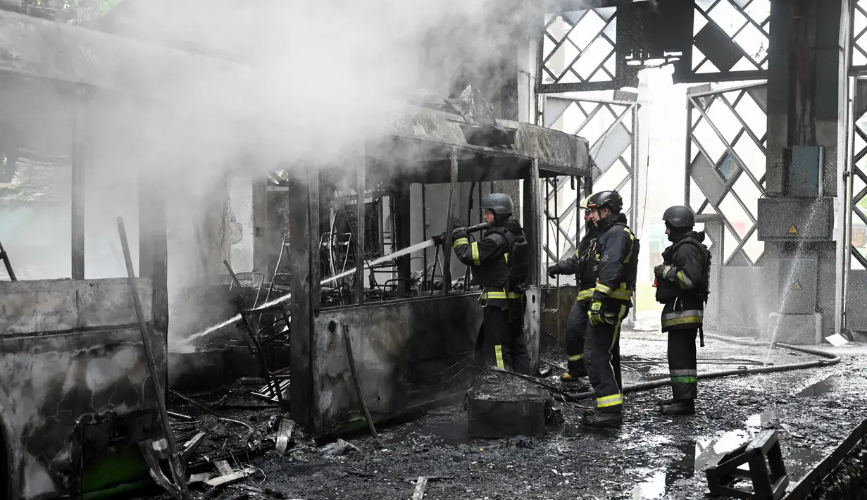 Tim penyelamat Ukraina bekerja untuk memadamkan api di sebuah terminal bus listrik setelah serangan pesawat tak berawak di Kharkiv pada 30 Mei 2025, di tengah-tengah invasi Rusia ke Ukraina. (SERGEY BOBOK/AFP)