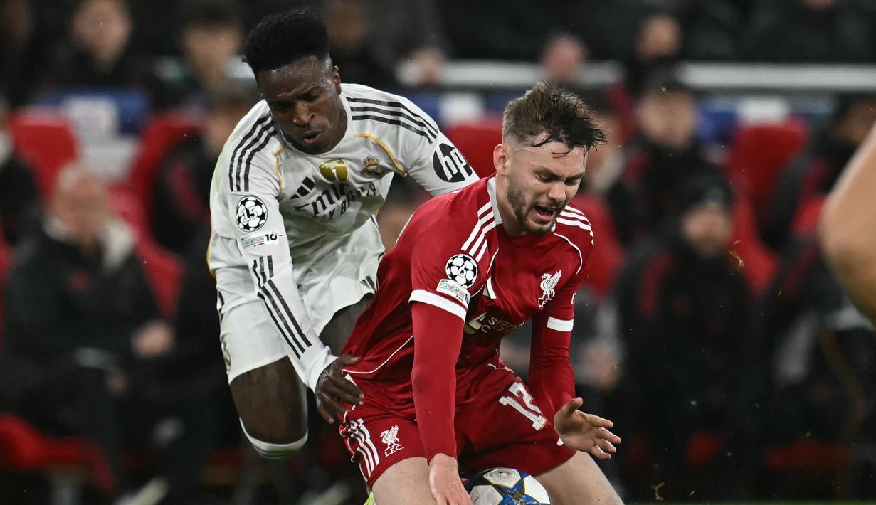Pemain Liverpool, Conor Bradley (kiri) berebut bola dengan pemain Real Madrid, Vinicius Jr dalam laga Liga Champions 2025/2026 di Anfield, Liverpool, Inggris, Selasa (04/11/2025) waktu setempat. (AFP/Paul Ellis)