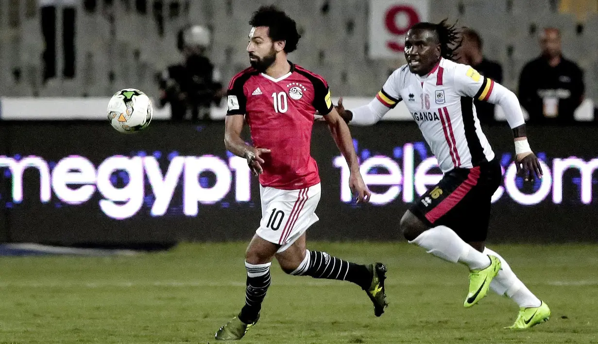 Pemain Mesir, Mohamed Salah (kiri) melewati adangan pemain Uganda, Hassan Wasswa pada laga kualifikasi Piala Dunia 2018 di Borg El Arab Stadium, Alexandria, Mesir (5/9/2017). Mesir menang 1-0. (AP/Nariman El-Mofty)