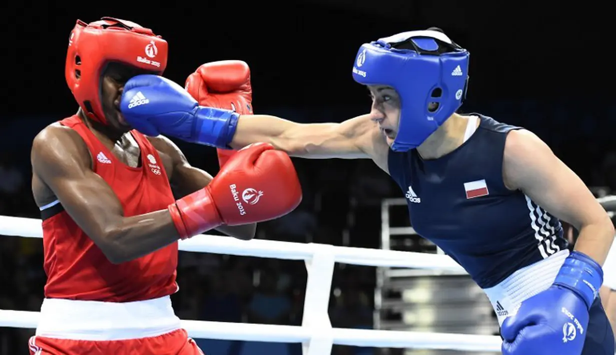 Petinju wanita Polandia, Sandra Drabik (kanan) memukul muka petinju Inggris Raya, Nicola Adams, saat bertanding di final kelas terbang wanita (48-51kg) dalam Pesta Olah Raga Eropa 2015 di Baku, Azerbaijan. (25/6). (AFP PHOTO/TOBIAS SCHWARZ)