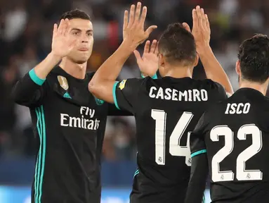 Striker Real Madrid, Cristiano Ronaldo bersama Casemiro, merayakan gol ke gawang Al-Jazira pada laga semifinal Piala Dunia Antarklub 2017 di Stadion Zayed Sport City, Rabu (13/12/2017). Real Madrid menang 2-1 atas Al-Jazira. (AFP/Karim Sahib)