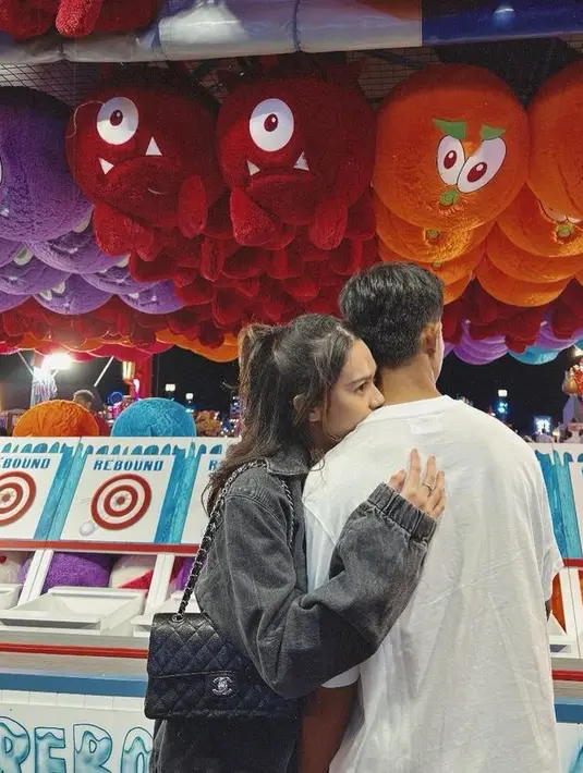 Peluk mersha sang suami, Azizah mengenakan jaket denim sambil membawa tas Chanel warna hitam.  [@azizahsalsha_]