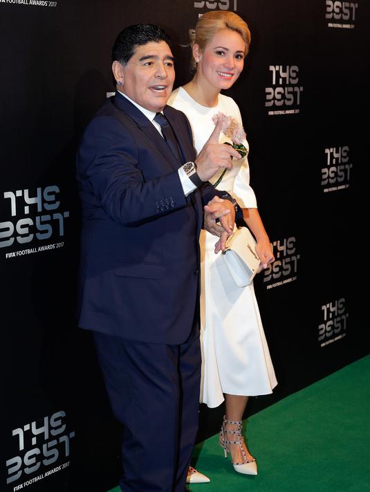 Diego Maradona bersama kekasihnya, Rocio Oliva berpose saat tiba menghadiri The Best FIFA Football Awards 2017 di London, Inggris (23/10). Rocio berusia 23 tahun  merupakan kekasih Maradona sejak lebih dari 3 tahun lalu. (AP Photo/Alastair Grant)