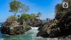 Warga asal Lamongan berjalan menikmati keindahan Lembah Watu Pawon di Desa Wisata Nglebeng, Kecamatan Panggul, Trenggalek, Jumat (01/09/2023). (merdeka.com/Arie Basuki)
