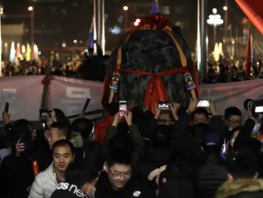 Orang-orang merayakan kedatangan kapsul pembawa pulang (return capsule) wahana antariksa China, Chang'e-5, di Akademi Teknologi Luar Angkasa China di Beijing, ibu kota China (17/12/2020). Kapsul tersebut diterbangkan ke Beijing pada Kamis (17/12) malam waktu setempat. (Xinhua/Jin Liwang)